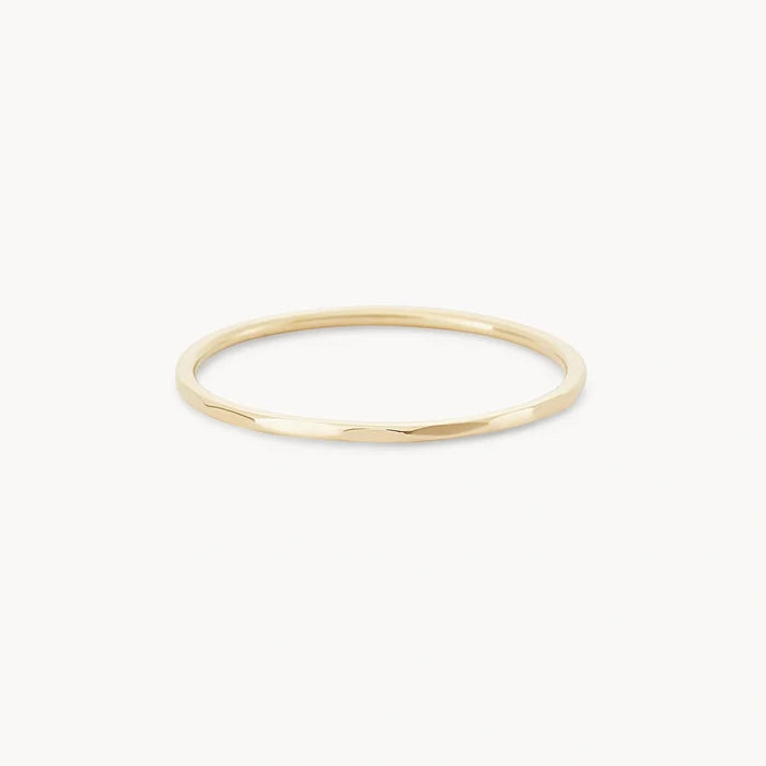 The Faceted Felicity stacking ring in 10k yellow gold by bluboho is showcased against a plain white background. This minimalist and elegant ring features a slightly polished finish, making it perfect for various occasions.
