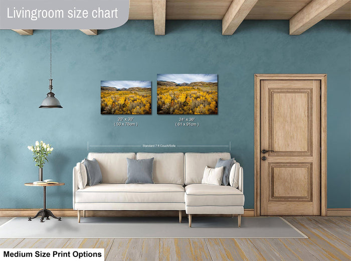 a living room with a white sofa, a wooden door, and a painting of a field of flowers hanging on the wall.