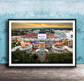 The image is a framed photograph of the Ben Hill Griffin Stadium inUF, Florida, with a sunset sky in the background.