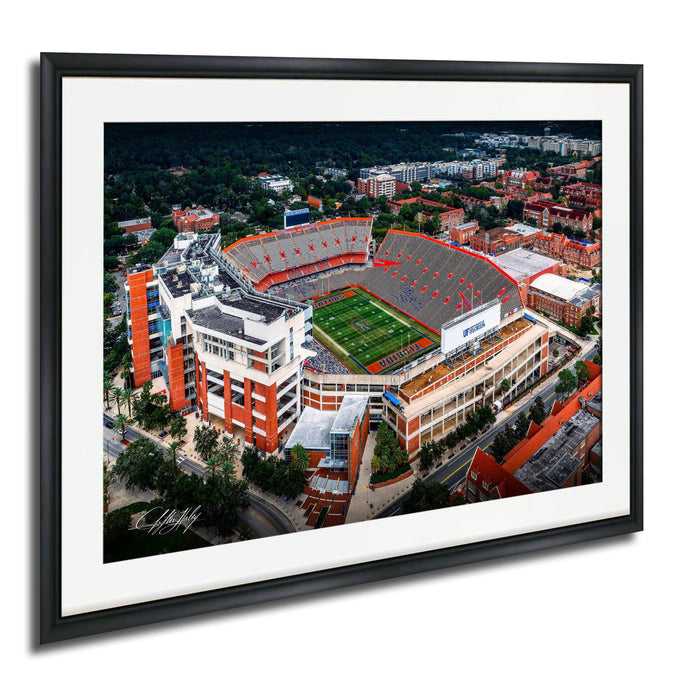 An aerial view of a large sports stadium with a football field, surrounded by buildings and other structures.