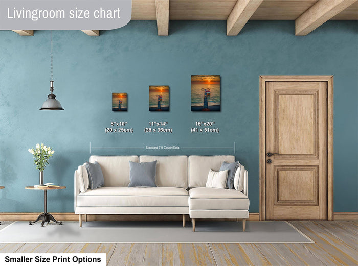 a living room with a white sofa, a wooden door, and a painting on the wall. The painting is of a sunset over the ocean. The living room appears to be designed for relaxation and comfort, with a cozy atmosphere.