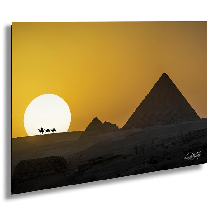 a desert landscape with the iconic pyramids of Giza silhouetted against a vibrant orange and yellow sunset sky.