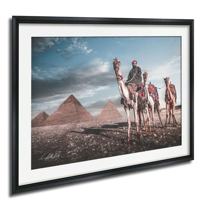A man riding a camel in front of the iconic pyramids of Giza, Egypt.