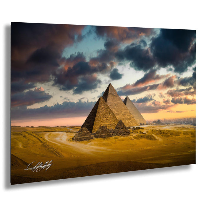 the iconic pyramids of Giza in Egypt, with dramatic clouds and a vibrant sunset sky in the background.
