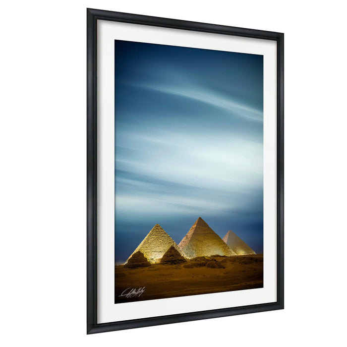 three pyramids against a blue sky with wispy clouds.