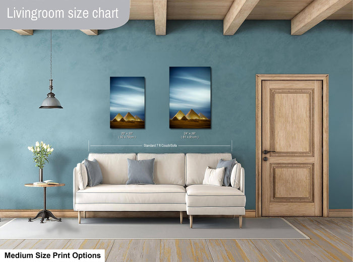 a living room with a white sofa, a wooden door, and two framed pictures of the pyramids of Giza hanging on the wall.