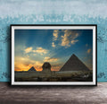 the Great Pyramids of Giza against a stunning sunset sky, with the Sphinx in the foreground.