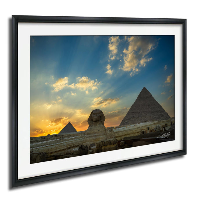 the Great Pyramids of Giza against a vibrant sunset sky, with the Sphinx in the foreground.