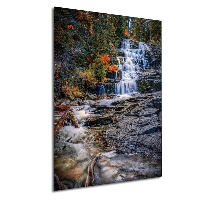 A picturesque waterfall cascading down a rocky cliff surrounded by vibrant autumn foliage.