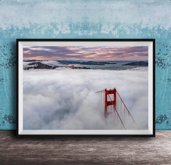 A framed photograph depicting the Golden Gate Bridge in foggy conditions, with the bridge's iconic red towers visible through the mist.