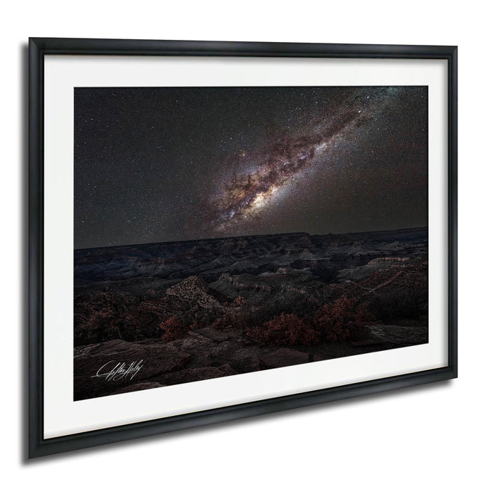 a breathtaking view of a starry night sky over a rugged, mountainous landscape.