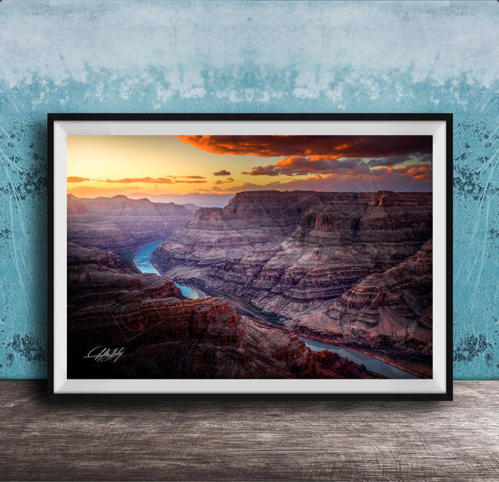 A framed photograph of a breathtaking view of the Grand Canyon, with a stunning sunset over the rugged, layered rock formations.