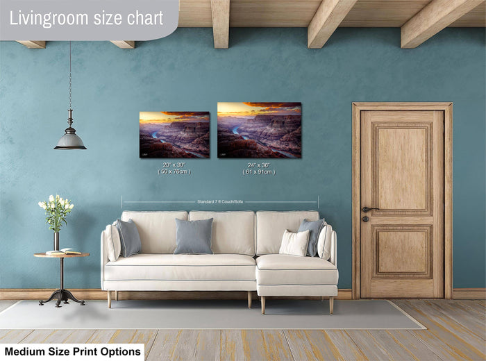 a living room with a white sofa, a wooden door, and a painting of a sunset landscape hanging on the wall.