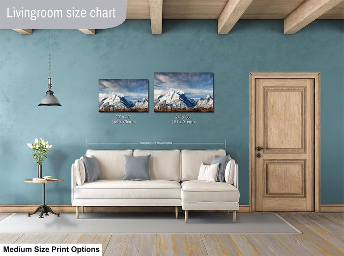 a living room with a white sofa, a wooden door, and a painting of a mountain landscape on the wall.
