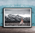 A framed photograph of a teepee in a snowy mountain landscape, with a blue wall in the background.
