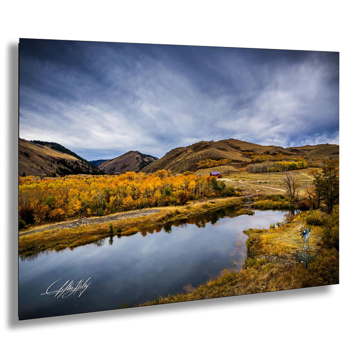 a serene landscape with a calm lake surrounded by mountains and trees with autumn foliage.