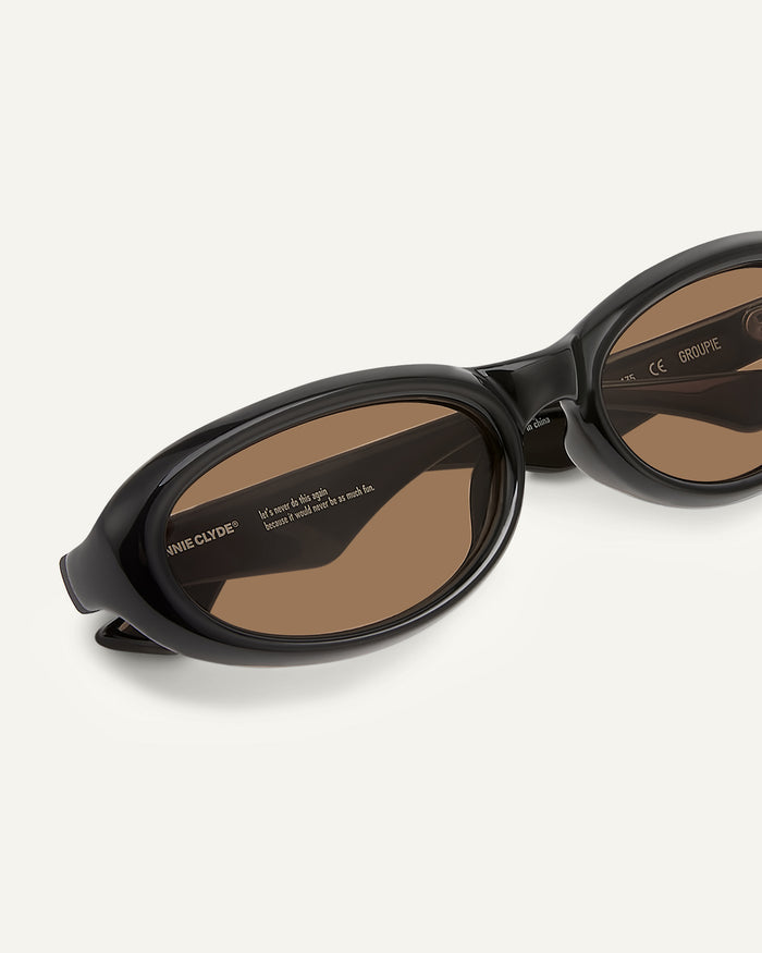 Close-up shot of Bonnie Clyde Groupie sunglasses in black with brown lenses.