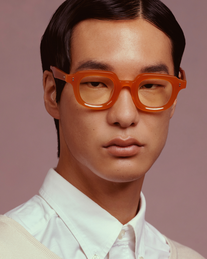 Quarter shot of Bonnie Clyde Gustave optical frames in orange with clear lenses.