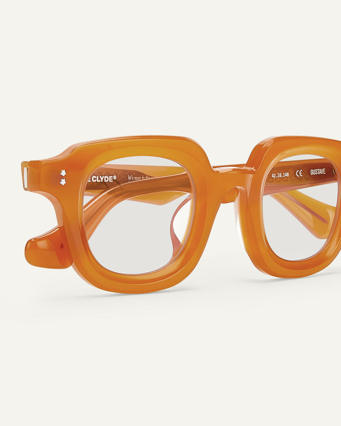 Close-up shot of Bonnie Clyde Gustave optical frames in orange with clear lenses.
