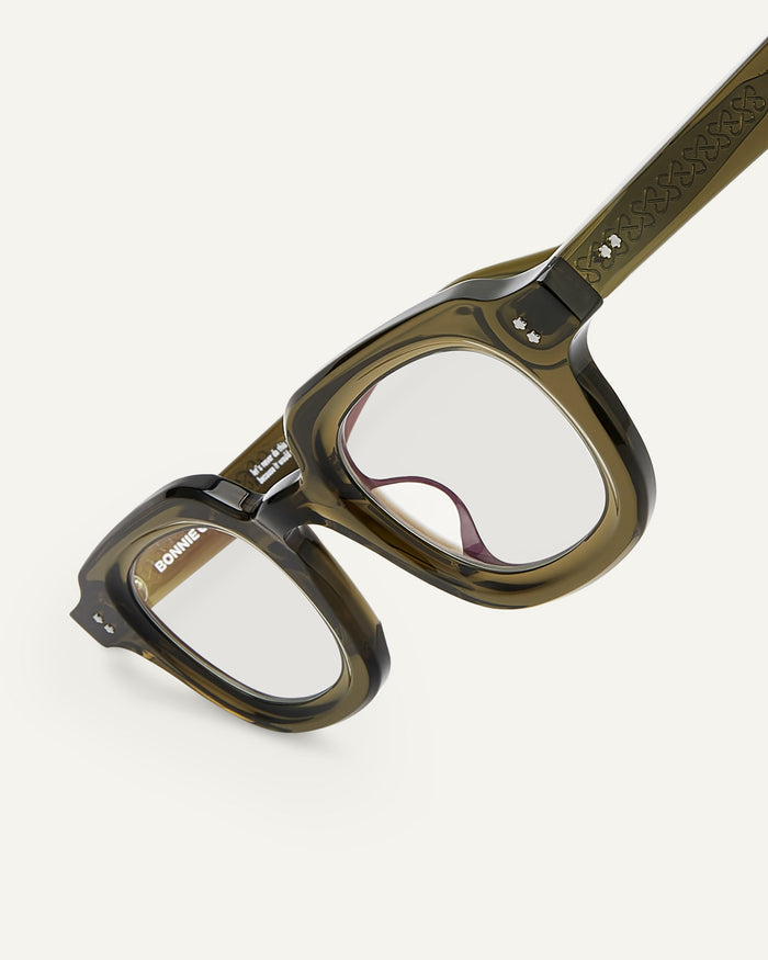 Close-up shot of Bonnie Clyde Gustave optical frames in dark green with clear lenses.