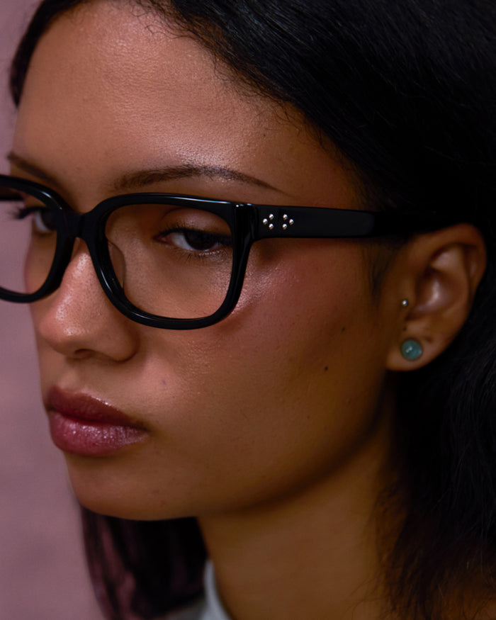 Quarter shot of Bonnie Clyde Guts optical frames in black with clear lenses.