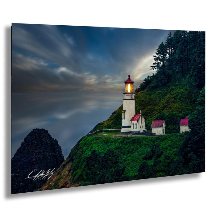 A picturesque lighthouse perched atop a cliff, overlooking the ocean at dusk.