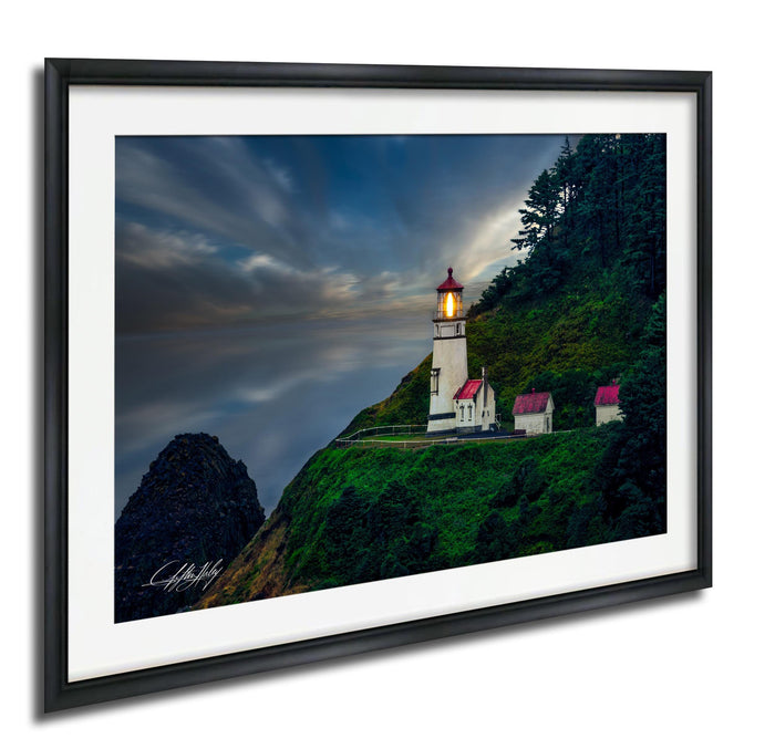 A framed photograph depicting a lighthouse on a cliff, with a dramatic sky and clouds in the background.