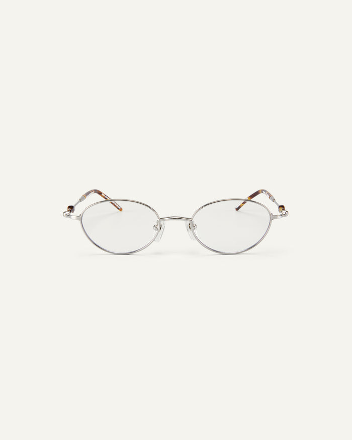 Face shot of Bonnie Clyde Heirloom optical frames in silver and tortoise with clear lenses.