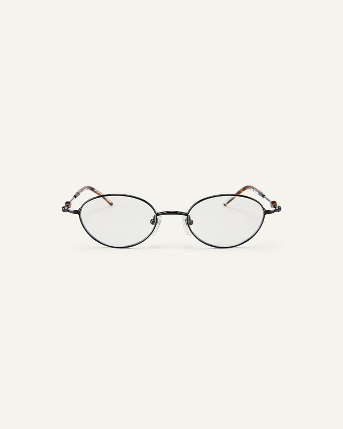 Face shot of Bonnie Clyde Heirloom optical frames in black and tortoise with clear lenses.