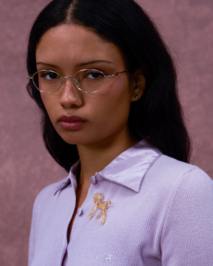 Quarter shot of Bonnie Clyde Heirloom optical frames in gold and dark brown with clear lenses.