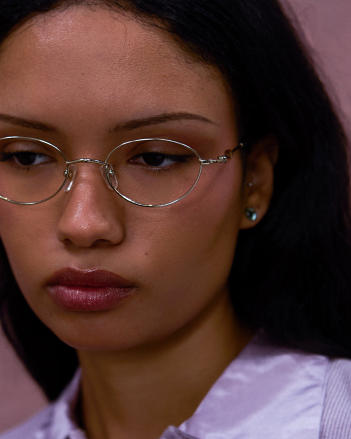 Side shot of Bonnie Clyde Heirloom optical frames in gold and dark brown with clear lenses.