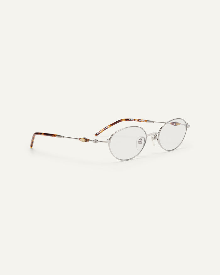 Side shot of Bonnie Clyde Heirloom optical frames in silver and tortoise with clear lenses.