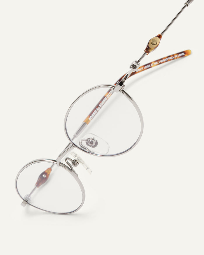 Close-up shot of Bonnie Clyde Heirloom optical frames in silver and tortoise with clear lenses.