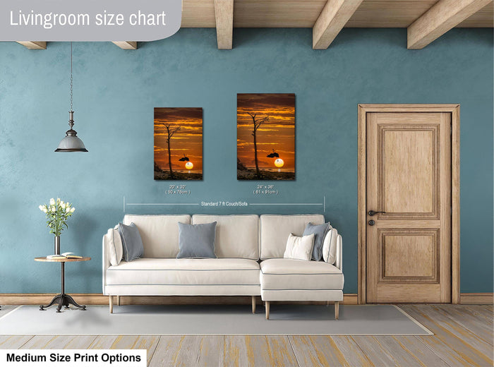 a living room with a white sofa, a wooden door, and a painting of a sunset on the wall.