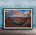 A framed photograph of the Grand Canyon, showcasing the stunning natural landscape with a winding river and dramatic clouds in the sky.