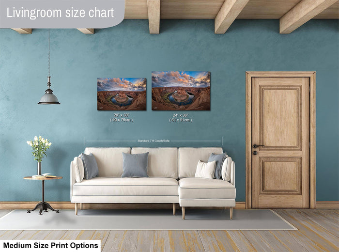 a living room with a white sofa, a wooden door, and a painting of a desert landscape on the wall. The living room appears to be well-lit and decorated with a potted plant and a vase.