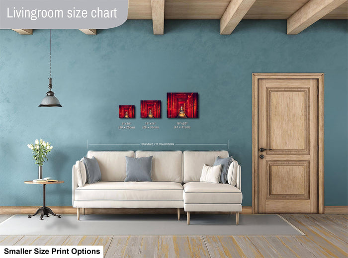a living room with a white sofa, a wooden door, and a hanging light fixture. There are three framed artworks displayed on the wall, each with a different size and style. The living room appears to be well-decorated and spacious.