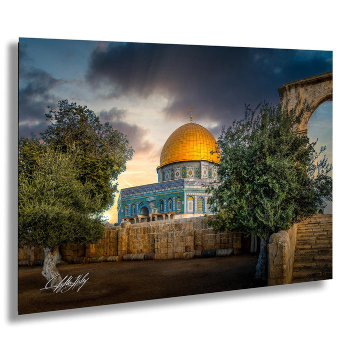 a large, ornate dome with a golden roof, surrounded by lush greenery and a stone wall. The sky is filled with clouds, creating a dramatic backdrop for the architectural structure.