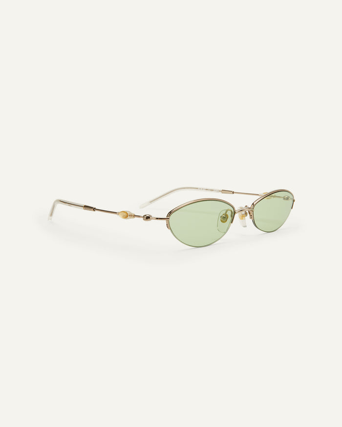 Quarter shot of Bonnie Clyde Jewel sunglasses in gold with green lenses.