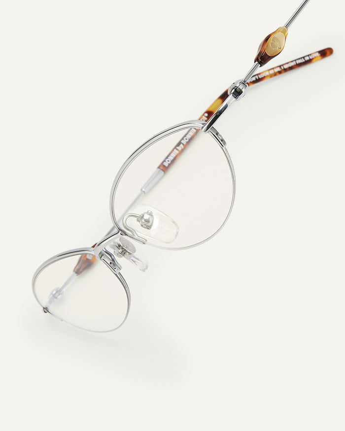 Side shot of Bonnie Clyde Jewel optical frames in silver and tortoise with clear lenses.