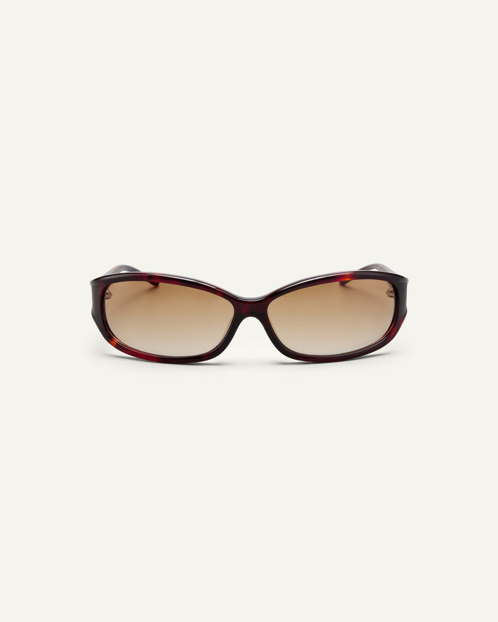 Face shot of Bonnie Clyde Joans sunglasses in red tortoise with brown gradient lenses.