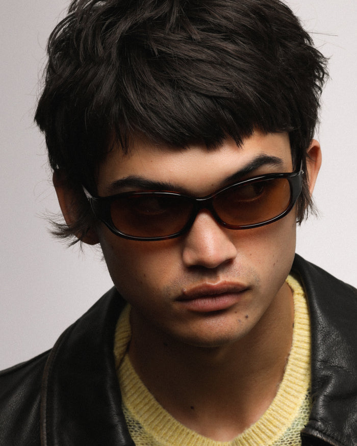 Quarter shot of Bonnie Clyde Joans sunglasses in red tortoise with brown gradient lenses.