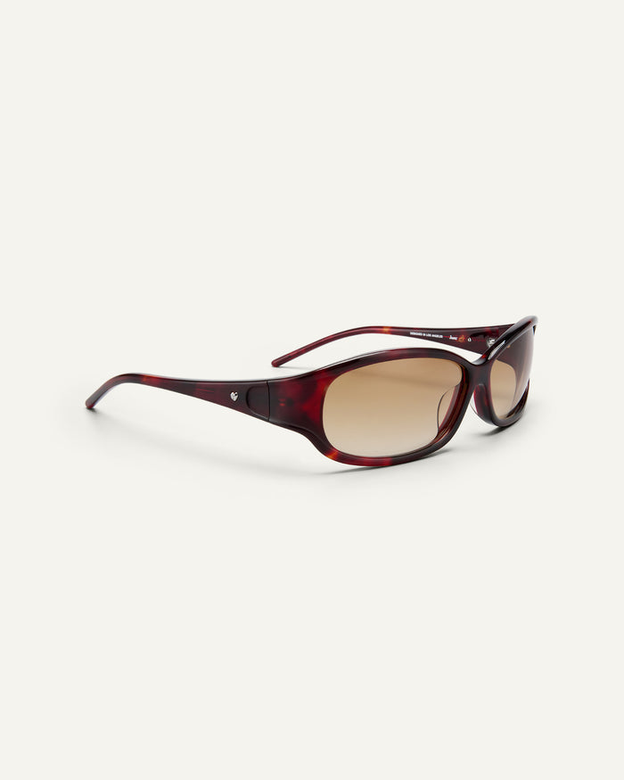 Side shot of Bonnie Clyde Joans sunglasses in red tortoise with brown gradient lenses.