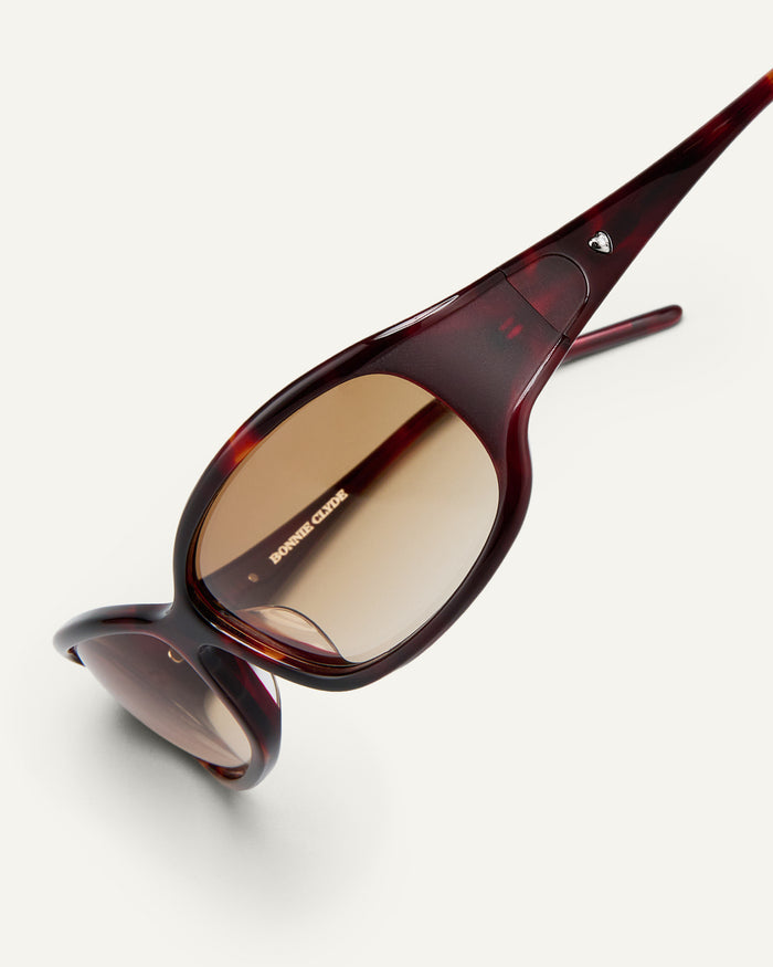 Detail shot of Bonnie Clyde Joans sunglasses in red tortoise with brown gradient lenses.