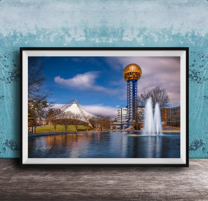 A framed photograph of the iconic Space Needle in Nashville, Tennessee, with a fountain in the foreground and a blue sky with clouds in the background.