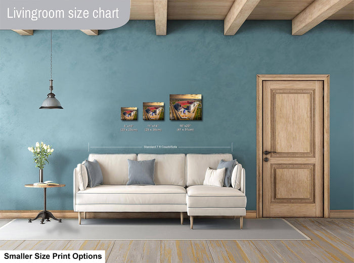 a living room with a white sofa, a wooden door, and a hanging light fixture. There are three framed artworks displayed on the wall above the sofa, each with different sizes and dimensions. The living room appears to be well-decorated and spacious.