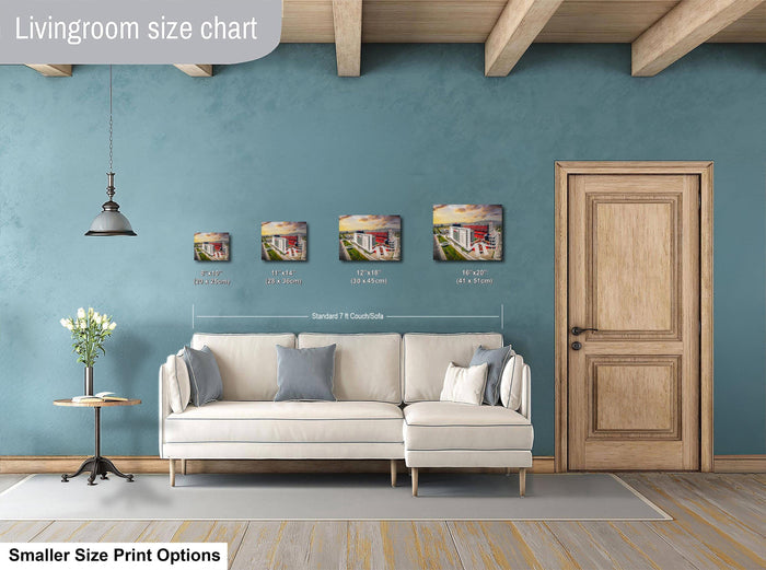 a living room with a white sofa, a wooden door, and a hanging light fixture. Above the sofa, there is a size chart indicating the dimensions of the artwork displayed on the wall.