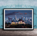 A framed photograph of the Los Angeles skyline at night, with the Griffith Observatory prominently featured in the foreground.