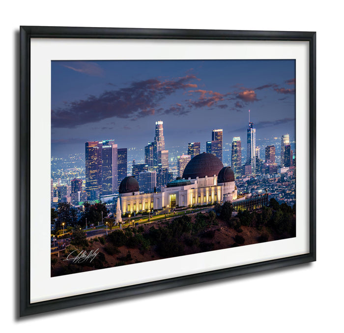A framed photograph of the Los Angeles skyline at night, featuring the Griffith Observatory and surrounding buildings illuminated against a dark sky.