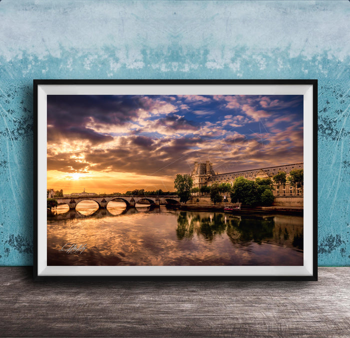 a picturesque scene of a river with a bridge, set against a stunning sunset sky with clouds.